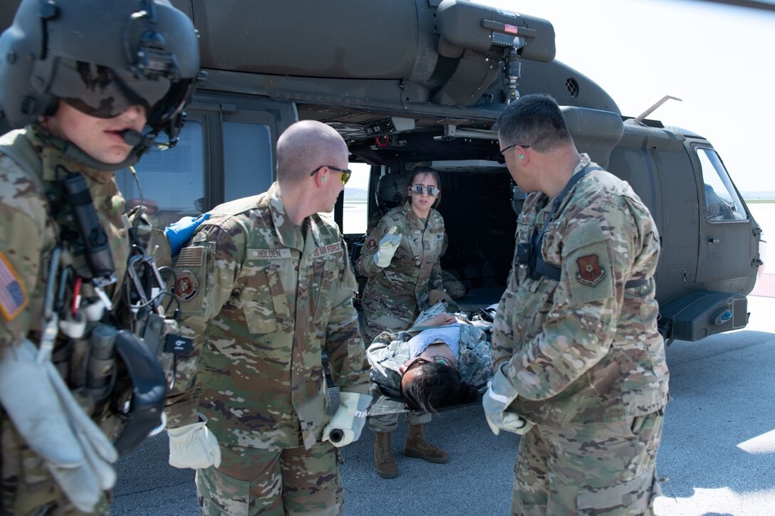 Members of the 28th Medical Group carry a simulated injured Army National Guardsman across the flight line during exercise Golden Coyote on Ellsworth Air Force Base, S.D., June 16, 2021