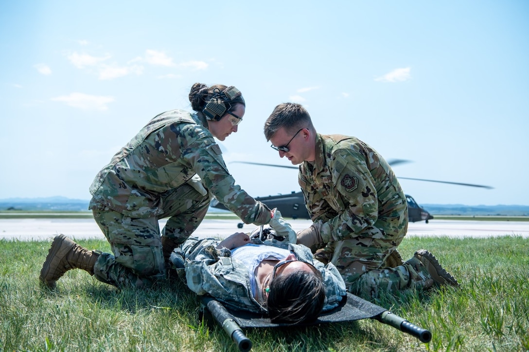 Capt. John Innins, a 375th Aeromedical Evacuation Squadron flight nurse, and Master Sgt. Amanda Tokarczyk, the 28th Operational Medical Readiness Squadron aerospace medicine flight chief, assist a “patient” on Ellsworth Air Force Base, S.D., June 16, 2021.