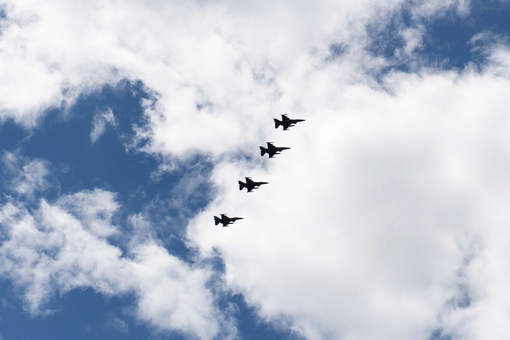 Photo of four F-16s flying.