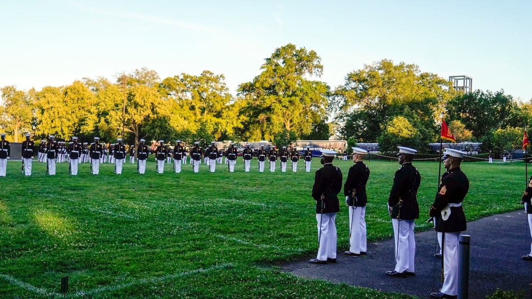 Marines with the parade staff stand at the position of during a Tuesday Sunset Parade at the Marine Corps War Memorial, Arlington, Va., June 29, 2021.