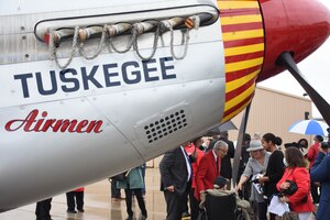 Tuskegee Airman retired Brig. Gen. Charles E. McGee, wearing a red blazer, poses for pictures with former Kansas City mayor Charles B. Wheeler near a Red-Tail P-51 Mustang painted to honor the Tuskegee Airmen