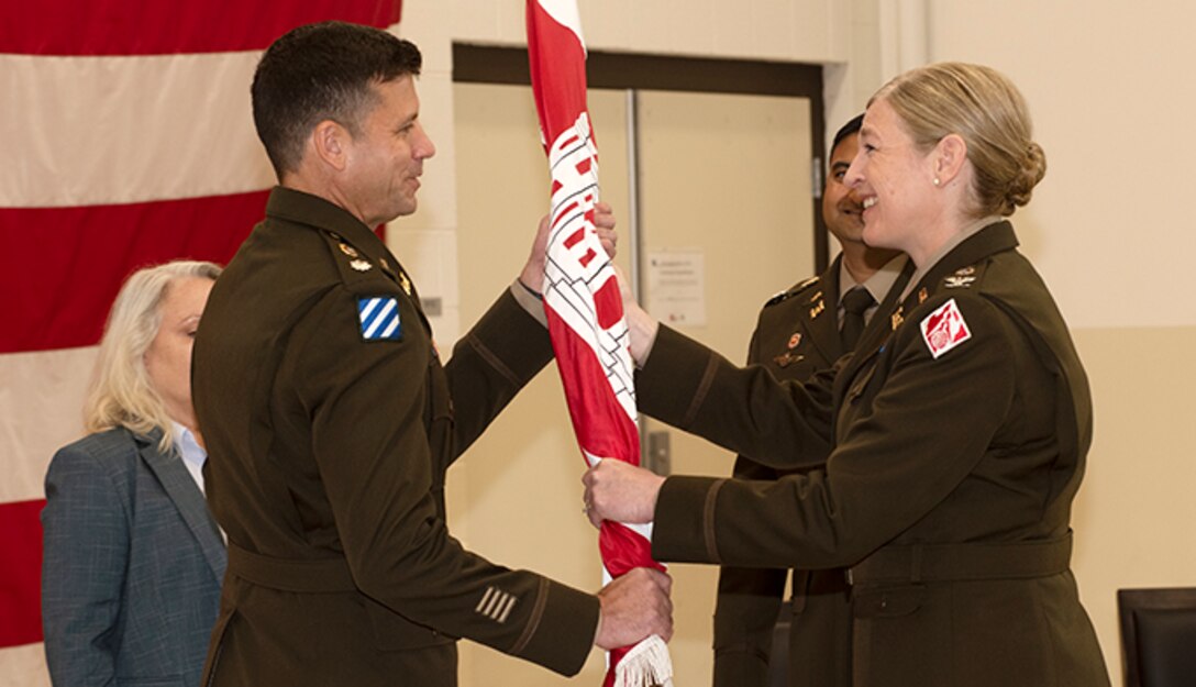 Col. Kimberly A. Peeples (Right), U.S. Army Corps of Engineers Great Lakes and Ohio River Division commander, passes the Nashville District flag to Lt. Col. Joe M. Sahl as he took command of the Nashville District during a change of command ceremony July 1, 2020 at the Tennessee National Guard Armory in Nashville, Tenn. (USACE photo by Lee Roberts)