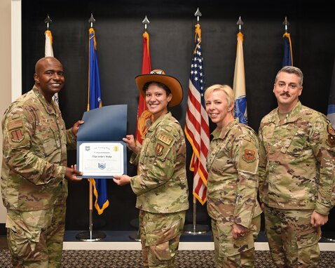 U.S. Air Force Col. James Finlayson, 17th Training Wing vice commander, presents Staff Sgt. Jackie Boykin, 315th Training Squadron instructor, a promotion certificate during the technical sergeant release party at the Event Center on Goodfellow Air Force Base, Texas, July 1, 2021. Air Force officials selected 9,422 of 34,973 eligible Staff Sergeants for promotion to Technical Sergeant for a selection rate of 26.94 percent. (U.S. Air Force photo by Senior Airman Abbey Rieves)