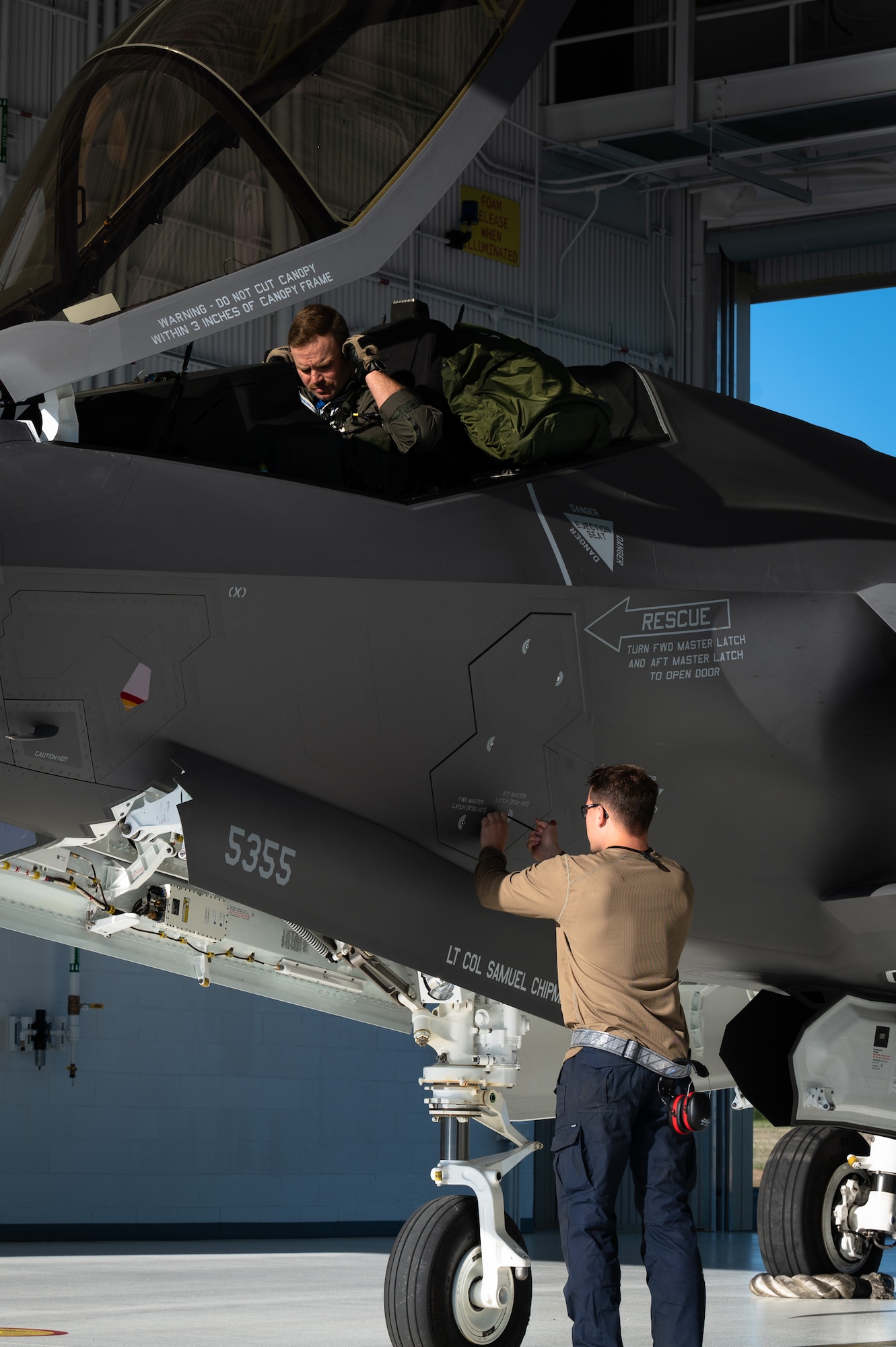 U.S. Air Force Lt. Col. Samuel Chipman, left, the 355th Fighter Squadron (FS) commander, conducts preflight inspections as an Airman assigned to the 355th Aircraft Maintenance Unit secures a panel on an F-35A Lightning II on Eielson Air Force Base, Alaska, July 1, 2021.