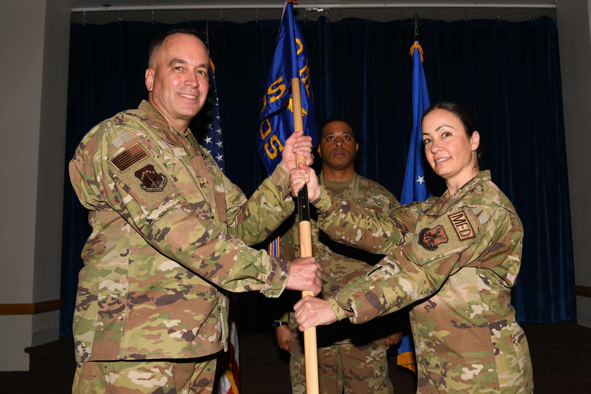 Col. Paul Toth, 90th Medical Group commander, passes the guidon to Lt. Col. Deborah Willis, 90th Healthcare Operations Squadron, during the 90 HCOS change of command ceremony July 1, 2021, at Trails End on F.E. Warren Air Force Base, Wyoming. The ceremony signified the transition of command from Col. David Barker to Willis. (U.S. Air Force photo by Airman 1st Class Charles Munoz)