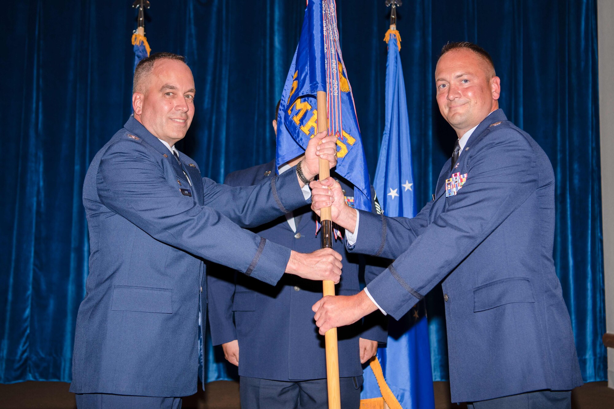 Col. Paul Toth, 90th Medical Group commander, passes the guidon to Lt. Col. Troy Novak, 90th Operational Medical Readiness Squadron, during the 90 OMRS Change of Command Ceremony July 1, 2021, at Trails End on F.E. Warren Air Force Base, Wyoming. The ceremony signified the transition of command from Col. Erin Knightner to Novak. (U.S. Air Force photo by Airman 1st Class Charles Munoz)