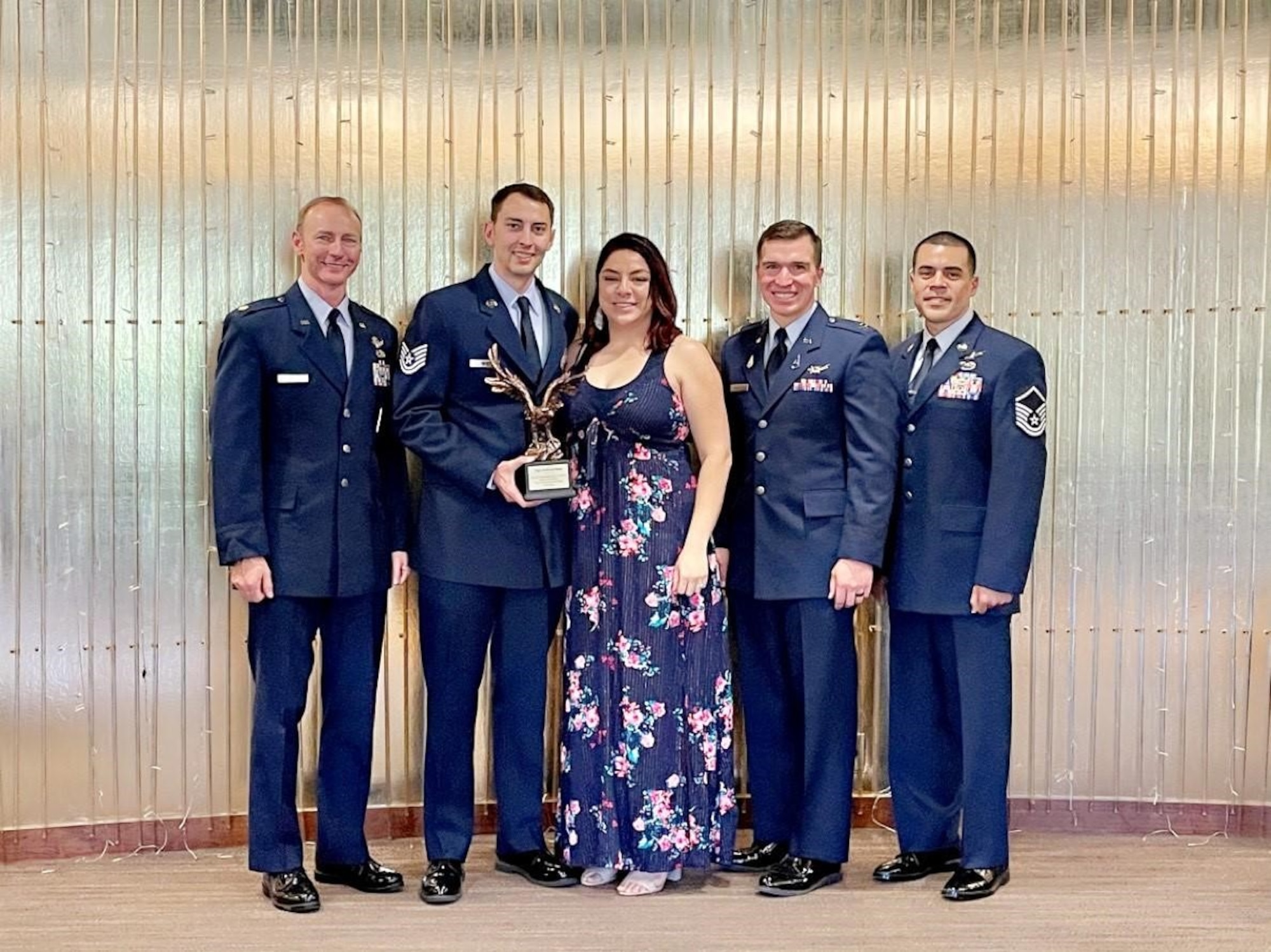 U.S. Air Force Master Sgt. Andrew New, Space Delta 3 – Space Electronic Warfare, 5th Space Control Squadron mission assurance flight chief (second from right, then a technical sergeant) poses after winning an Outstanding Enlisted Award from the Colorado Springs Chamber of Commerce and Economic Development Corporation’s Military Affairs Council in Colorado Springs, Colorado, May 14, 2021. New was joined by his wife (center) and fellow service members on this occasion, which honored the volunteer work he led fellow service members to undertake during the 2020 COVID-19 lockdowns. (Courtesy photo)