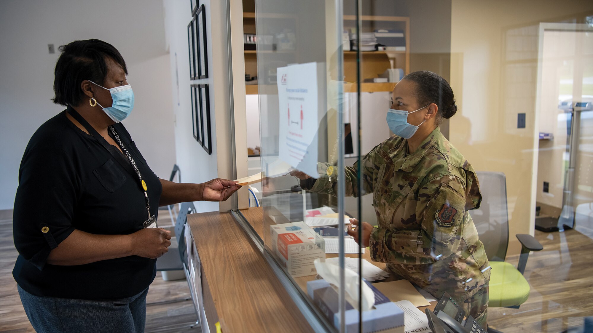 Tech. Sgt. Angela Thompson, 445th Aeromedical Staging Squadron medical administrator, hands a chart to a patient prior to receiving care at Hancock County Health Department, Hancock, Georgia, as part of the East Central Georgia Medical Innovative Readiness Training conducted on June 10, 2021.