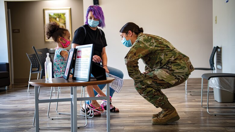 Image of an Airman talking to a family.