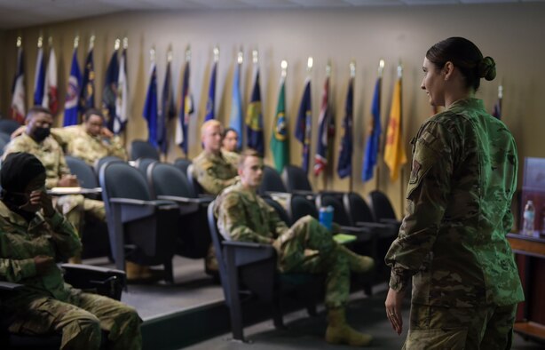 woman stands in front of group of people