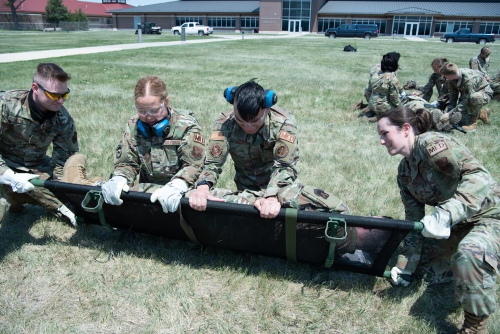 Members of 28th Medical Group practice how to properly strap a person to a litter for exercise Golden Coyote on Ellsworth Air Force Base, S.D., June 16, 2021.