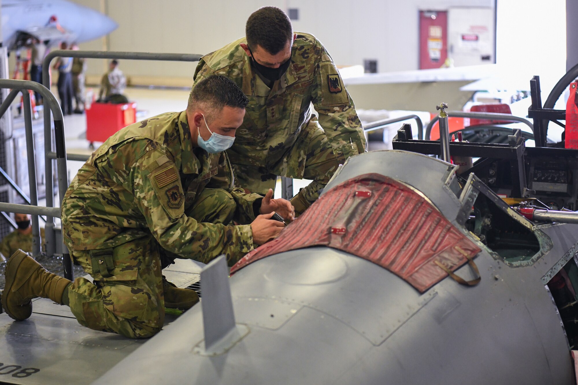 Lt Gen Loh kneels on F-15D with Airman