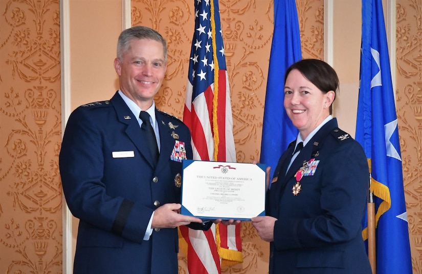 Photo of an individual receiving an award from another individual.