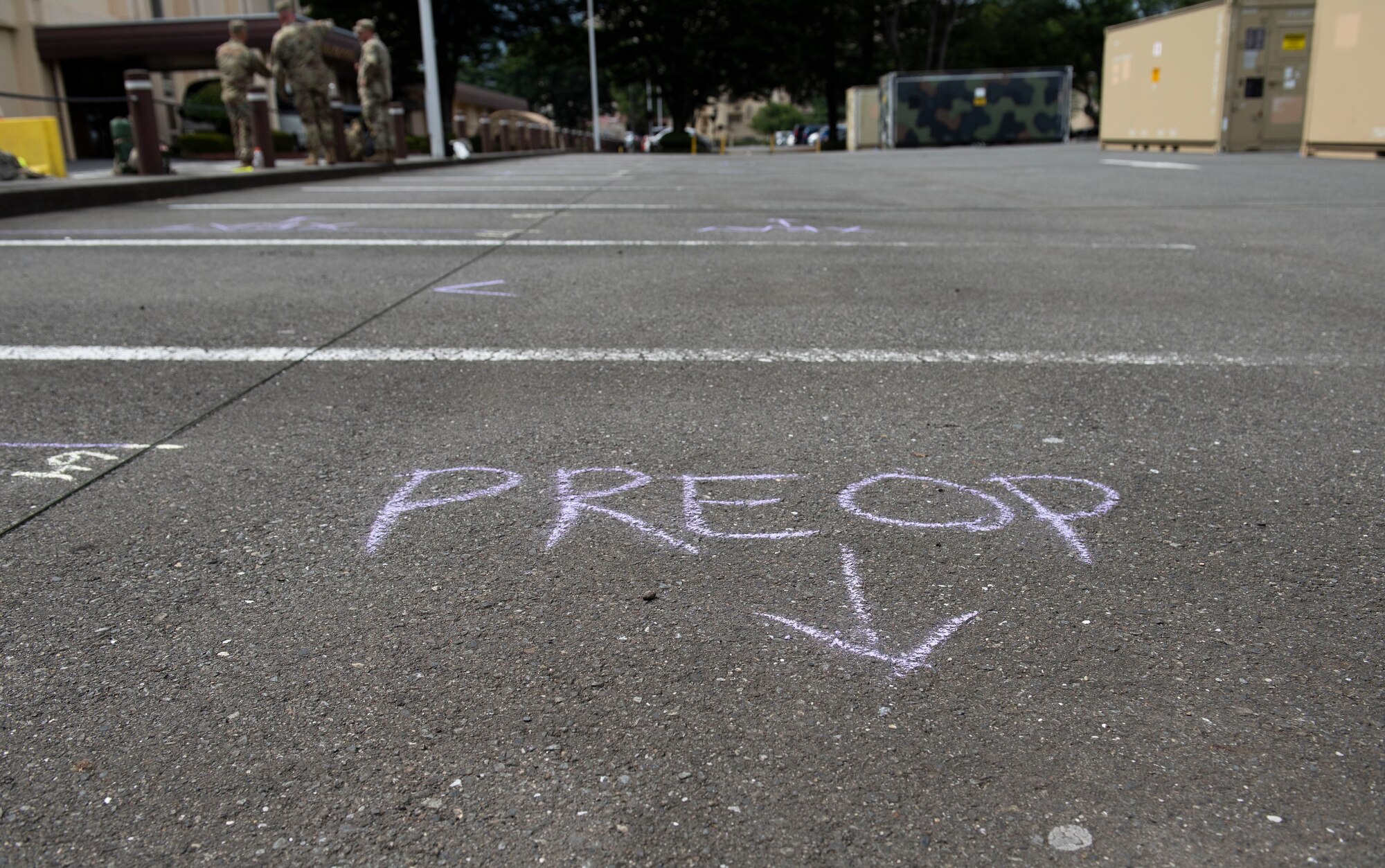 A chalk mark made by a 311th Field Hospital soldier from Blacklick, Ohio, indicates a spot for a medical tent during an Army field exercise at Yokota Air Base, Japan, June 24, 2021. When deployed the field hospital would be fully functional and come with a lab, intermediate care wards, X-ray, pharmacy and central medical supplies. (U.S. Air Force photo by Senior Airman Hannah Bean)