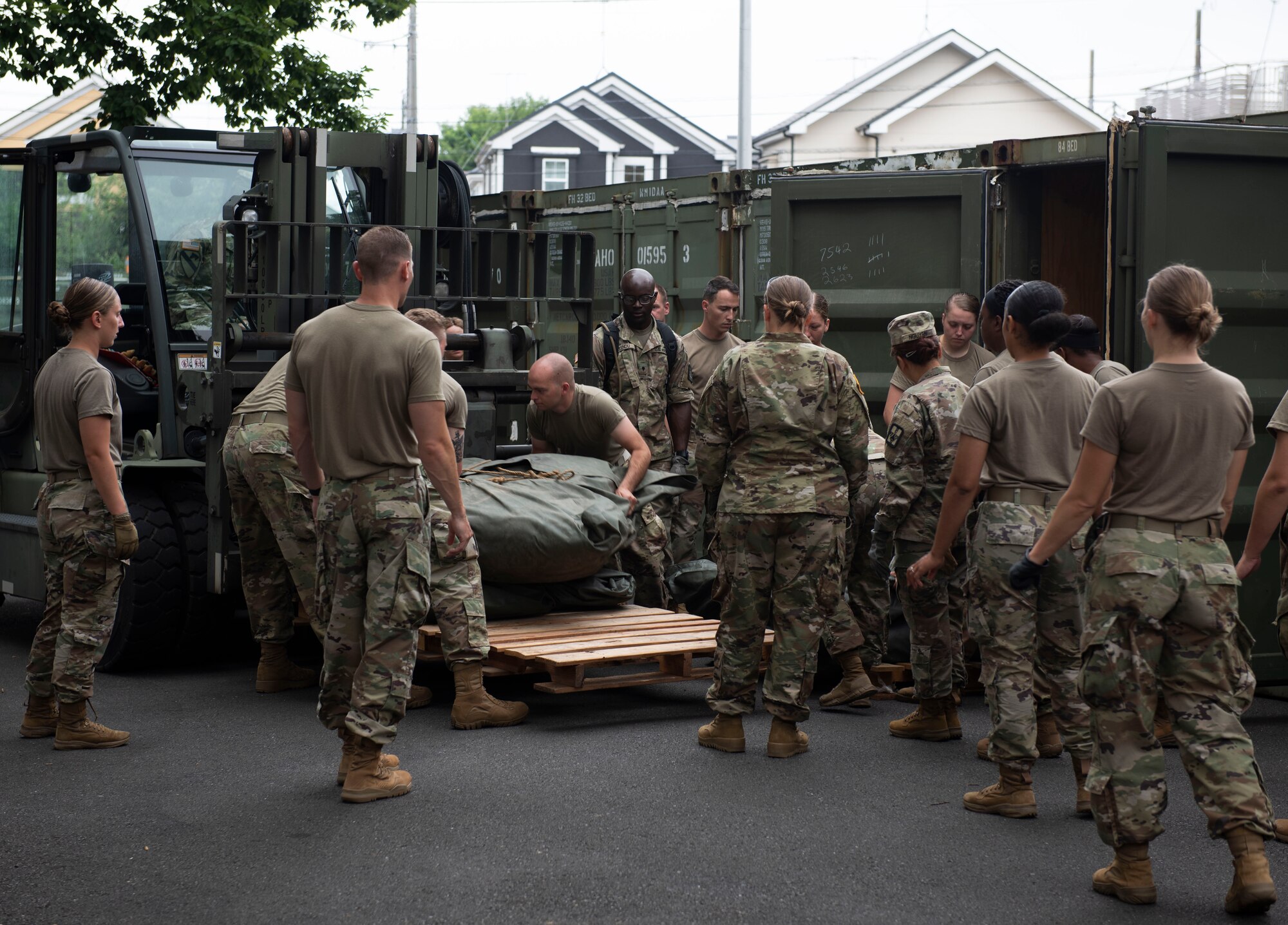 Soldiers from the 311th Field Hospital from Blacklick, Ohio, load materials on to a pallet prior to building a mock deployment hospital for an Army field exercise at Yokota Air Base, Japan, June 25, 2021. When deployed the field hospital would be fully functional and come with a lab, intermediate care wards, X-ray, pharmacy and central medical supplies. (U.S. Air Force photo by Senior Airman Hannah Bean)