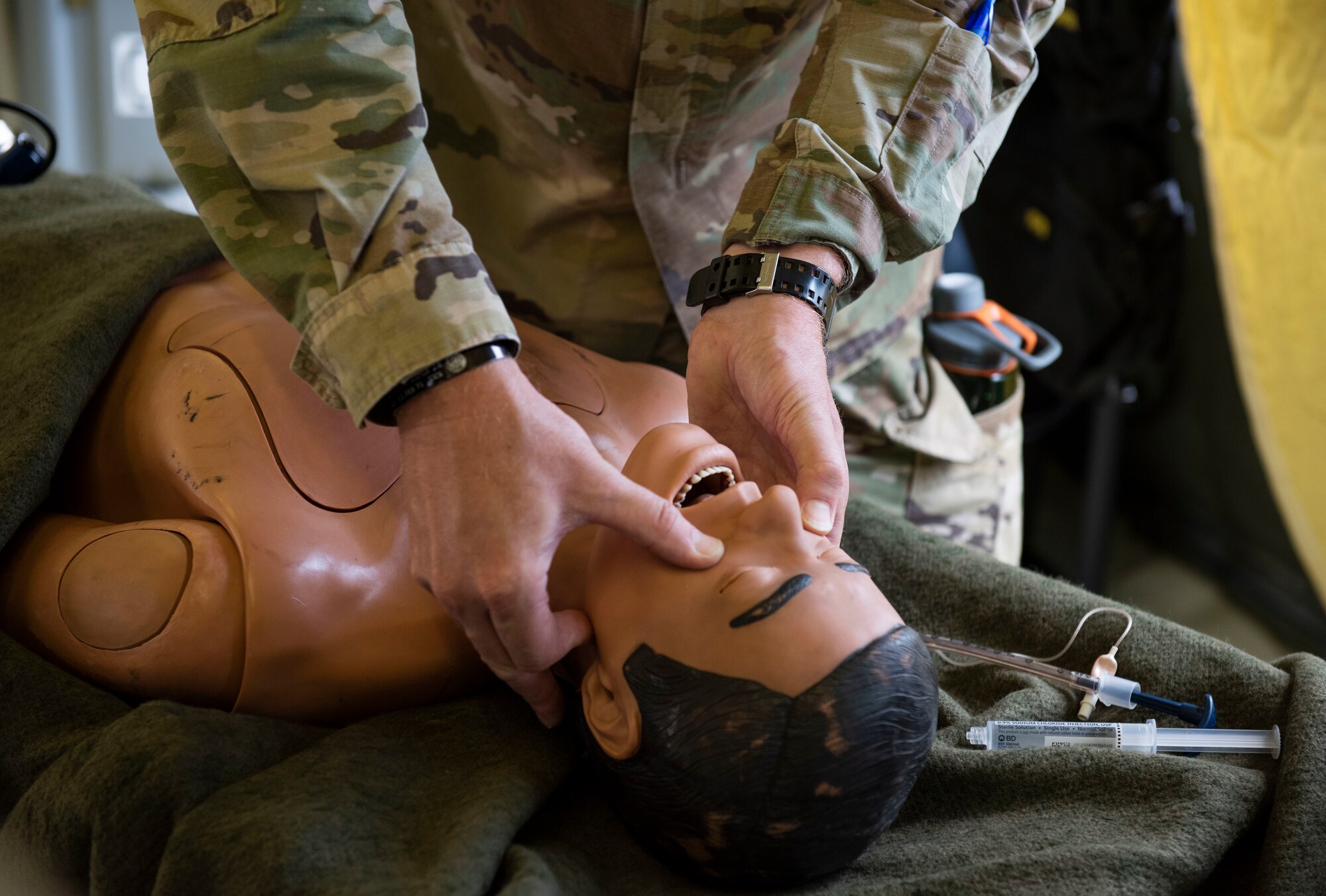 A soldiers from the 311th Field Hospital from Blacklick, Ohio, open an airway during an Army field exercise at Yokota Air Base, Japan, June 25, 2021. During the exercise, the 311th Field Hospital constructed a 32-bed hospital and performed a variety of simulated procedures to include installing IVs and providing sutures. (U.S. Air Force photo by Senior Airman Hannah Bean)