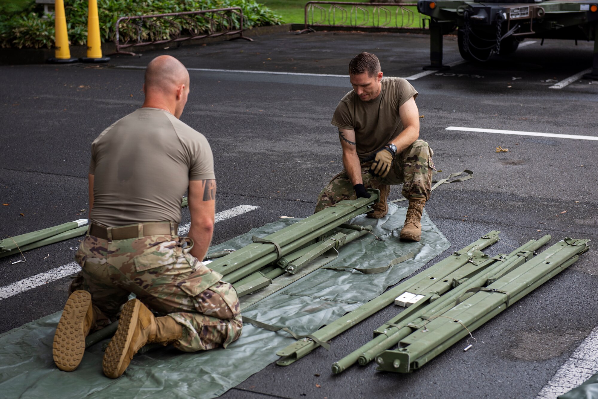 Soldiers from the 311th Field Hospital from Blacklick, Ohio, pack tent supports after an Army field exercise at Yokota Air Base, Japan, June 25, 2021. With the assistance of the 18th Medical Command and the 374th Airlift Wing, the 311th Field Hospital received the opportunity to mock forward deploy and practice setting up a 32-bed hospital in an unfamiliar location. (U.S. Air Force photo by Senior Airman Hannah Bean)