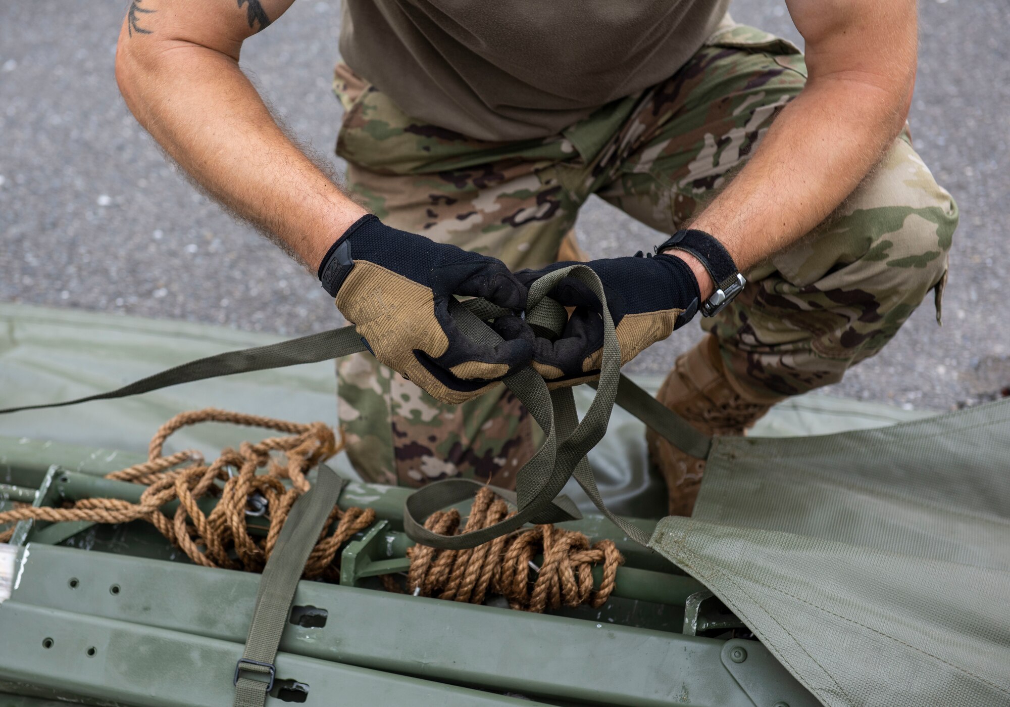 A soldier from the 311th Field Hospital from Blacklick, Ohio, bundles tent supports after an Army field exercise at Yokota Air Base, Japan, June 25, 2021. With the assistance of the 18th Medical Command and the 374th Airlift Wing, the 311th Field Hospital received the opportunity to mock forward deploy and practice setting up a 32-bed hospital in an unfamiliar location. (U.S. Air Force photo by Senior Airman Hannah Bean)