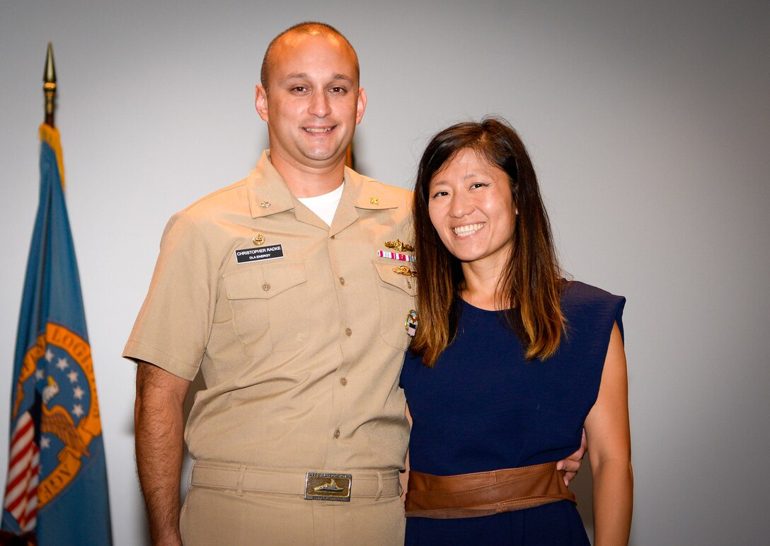 A Navy officer stands with his wife