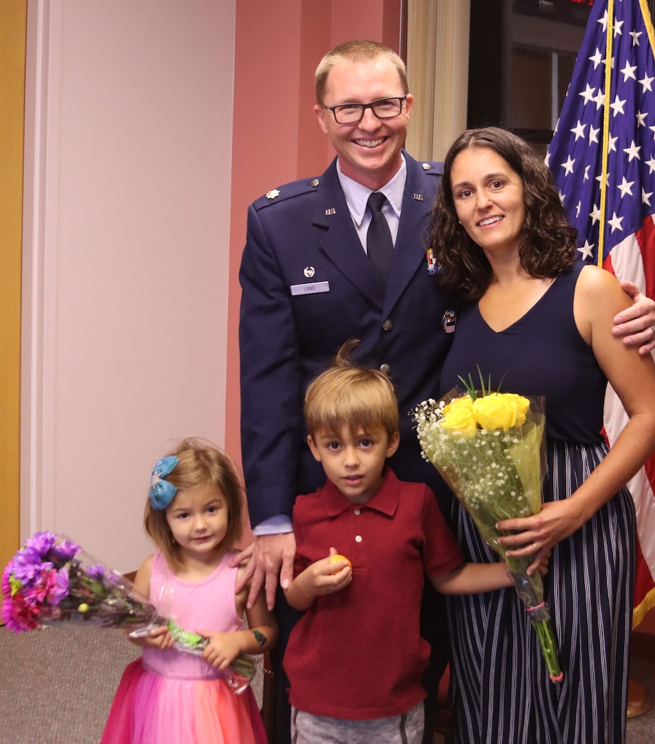 An Air Force officer stands with his family