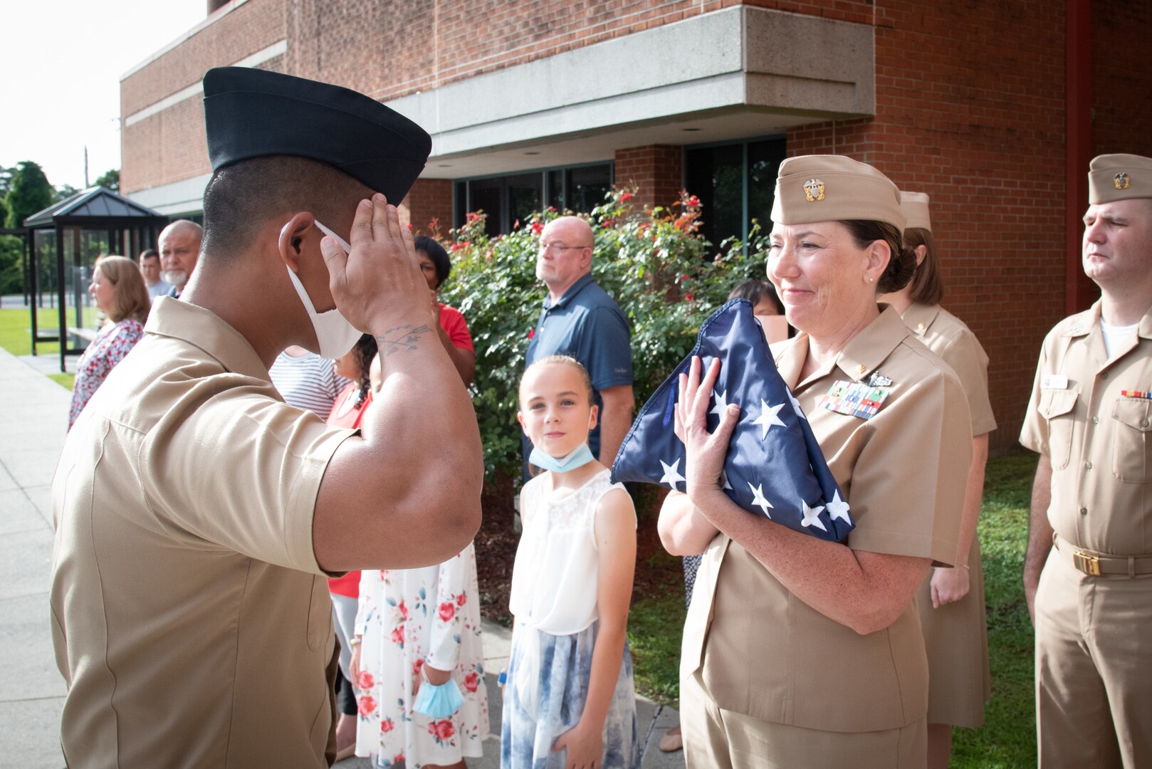 U.S. Navy Commander Tamera Corson receives a flag flown over Naval Health Clinic Cherry Point in a small ceremony held Friday, July 2 and attended by her staff and supervisors.  Corson served at the clinic as the Director for Healthcare Business, overseeing many administrative tasks and initiatives.