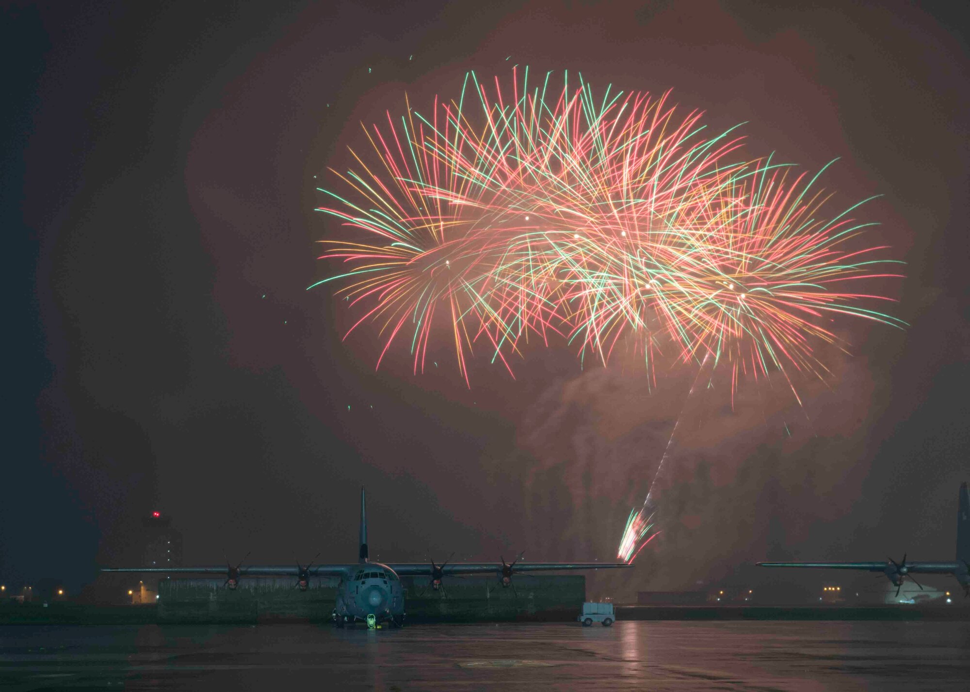 Fireworks explode behind a C-130J Super Hercules during a celebrate America at Yokota Air Base, Japan, July 2, 2021.