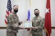 Brig. Gen. Justin Swanson, deputy commanding general, 1st Theater Sustainment Command, presents a Sustainer of the Week certificate Tech Sgt. Louis V. Closa, contracting officer, 408th Contracting Sustainment Brigade, recognizing him as the Sustainer of the Week at Camp Arifjan, Kuwait, June 26, 2021. Closa negotiated a $29.7 million contract for the Syrian Line Haul. (U.S. Army photo by Sgt. Jimmie Baker, 1TSC Public Affairs)