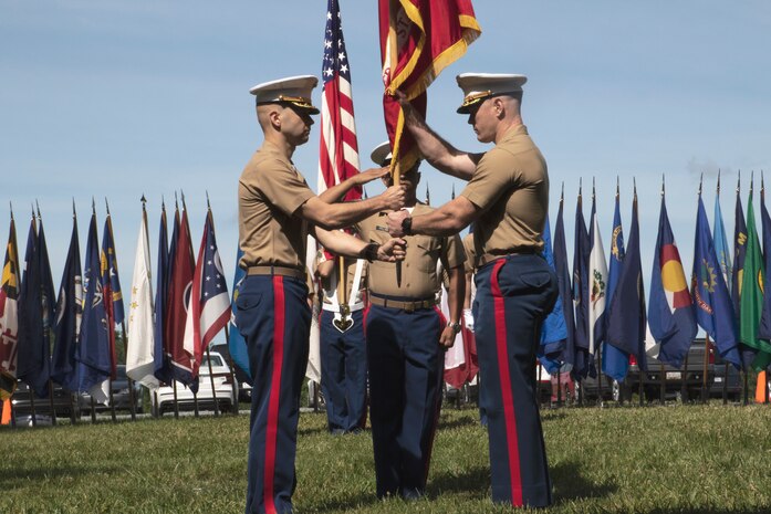 U.S. Marine Corps Maj. Daniel Chamberlin, left, oncoming commanding officer, Recruiting Station (RS) Frederick, Sgt. Maj. Michael Collins, senior enlisted advisor, RS Frederick, center, and Maj. Evan Fairfield, outgoing commanding officer of RS Frederick, right, preform the passing of the colors during the RS Frederick change of command ceremony on June 25, 2021. The ceremony represents the passing of leadership from Fairfield to Chamberlin. (U.S. Marine Corps photo by Sgt. Ryan Sammet)