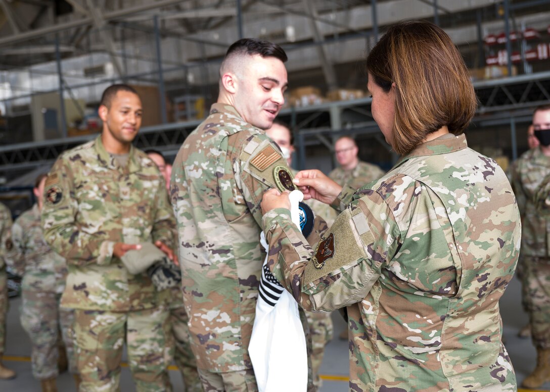 Chief Master Sgt. of the Air Force JoAnne S. Bass places her patch on Senior Airman Ian Pierce, 412th Aircraft Maintenance Squadron F-22 crew chief, after exchanging unit patches during her visit to Edwards Air Force Base, California, June 29. (Air Force photo by Giancarlo Casem)