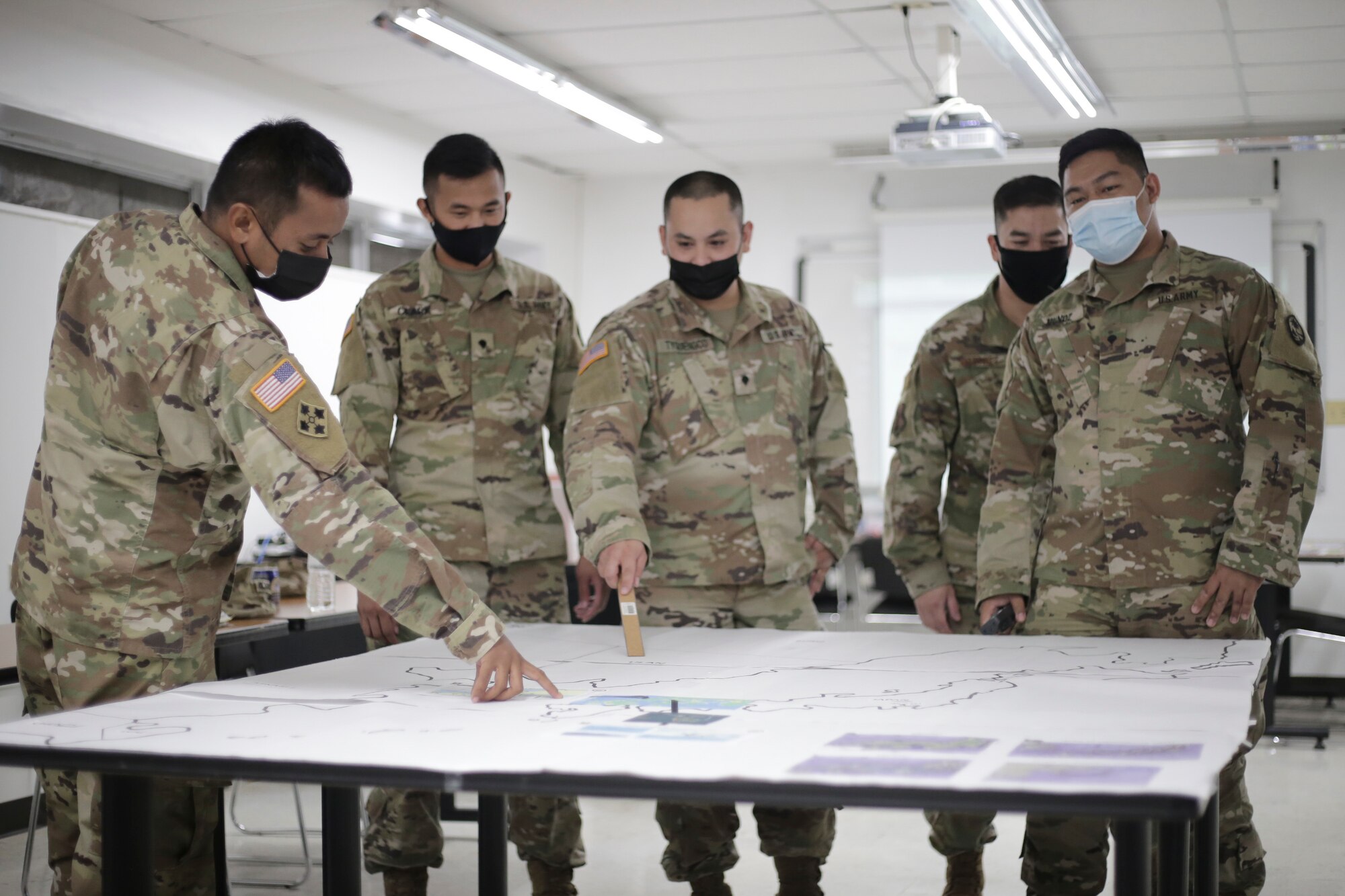 From left, Sgt. Randy Ngirmekur, Spc. Ken Clark, Spc. Avery Tyquienco, Senior Amn. Ryan Martinez, and Spc. Jeremy Munoz participates remotely in the Electronic Warfare and Cyber Defense portions of Exercise Orient Shield 21-2 in Dededo, Guam, on June 30.