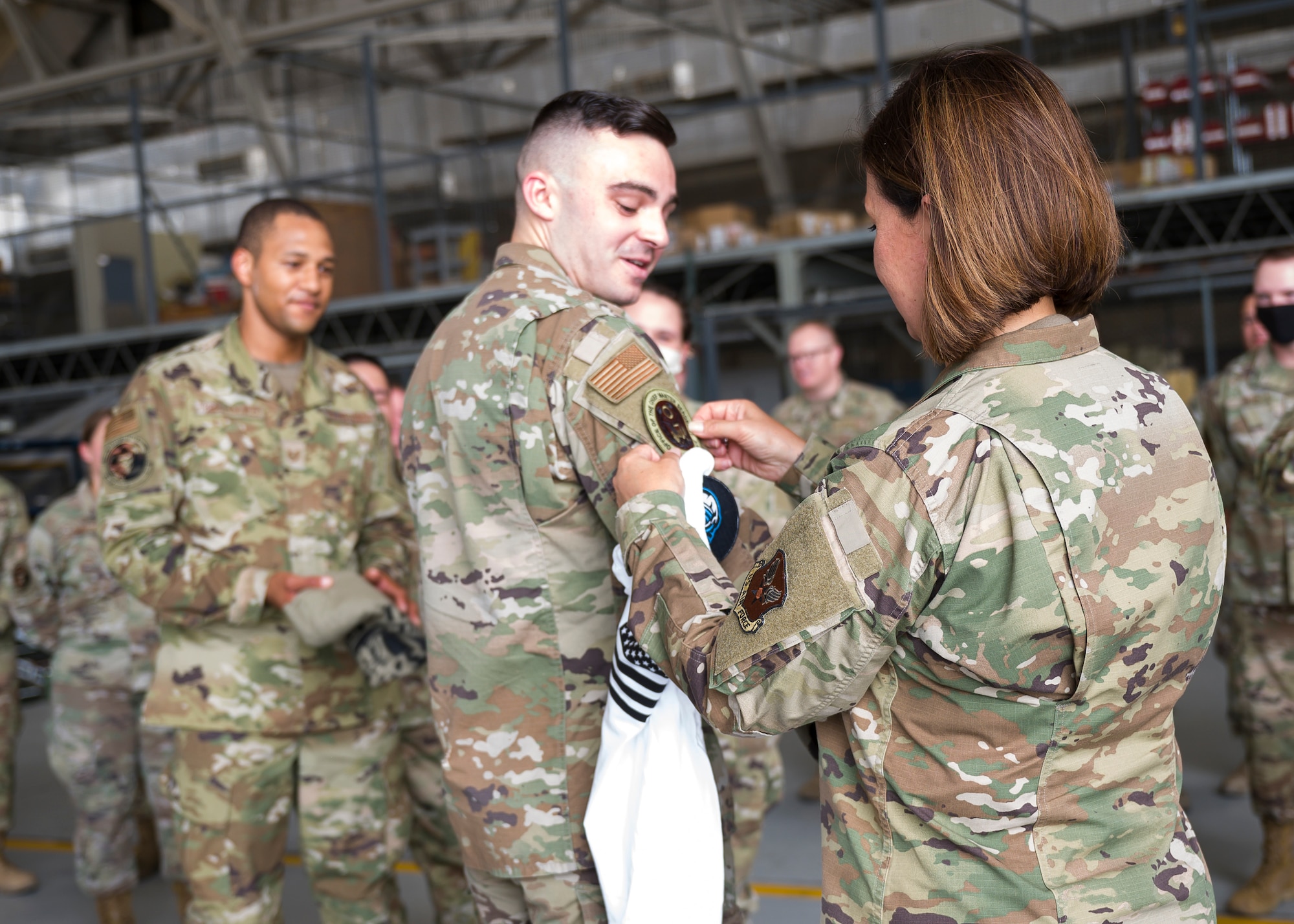 Chief Master Sgt. of the Air Force JoAnne S. Bass places her patch on Senior Airman Ian Pierce, 412th Aircraft Maintenance Squadron F-22 crew chief, after exchanging unit patches during her visit to Edwards Air Force Base, California, June 29. (Air Force photo by Giancarlo Casem)