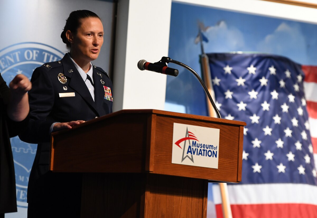 Photo shows Col. Droz standing behind podium on a stage.