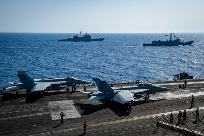 Sailors conduct flight operations on the flight deck of aircraft carrier USS Dwight D. Eisenhower (CVN 69) during a passing exercise with Egyptian Navy guided-missile frigate ENS Taba (FFG 916), right, and guided-missile cruiser USS Vella Gulf (CG 72) in the Red Sea, June 29. The Eisenhower Carrier Strike Group is deployed to the U.S. 5th Fleet area of operations in support of naval operations to ensure maritime stability and security in the Central Region, connecting the Mediterranean and Pacific through the western Indian Ocean and three strategic choke points.