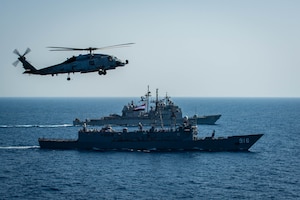 An MH-60R Sea Hawk helicopter, attached to the "Swamp Foxes" of Helicopter Maritime Strike Squadron (HSM) 74, flies above Egyptian Navy guided-missile frigate ENS Taba (FFG 916), front, and guided-missile cruiser USS Vella Gulf (CG 72) during a passing exercise with aircraft carrier USS Dwight D. Eisenhower (CVN 69), not pictured, in the Red Sea, June 29. The Eisenhower Carrier Strike Group is deployed to the U.S. 5th Fleet area of operations in support of naval operations to ensure maritime stability and security in the Central Region, connecting the Mediterranean and Pacific through the western Indian Ocean and three strategic choke points.