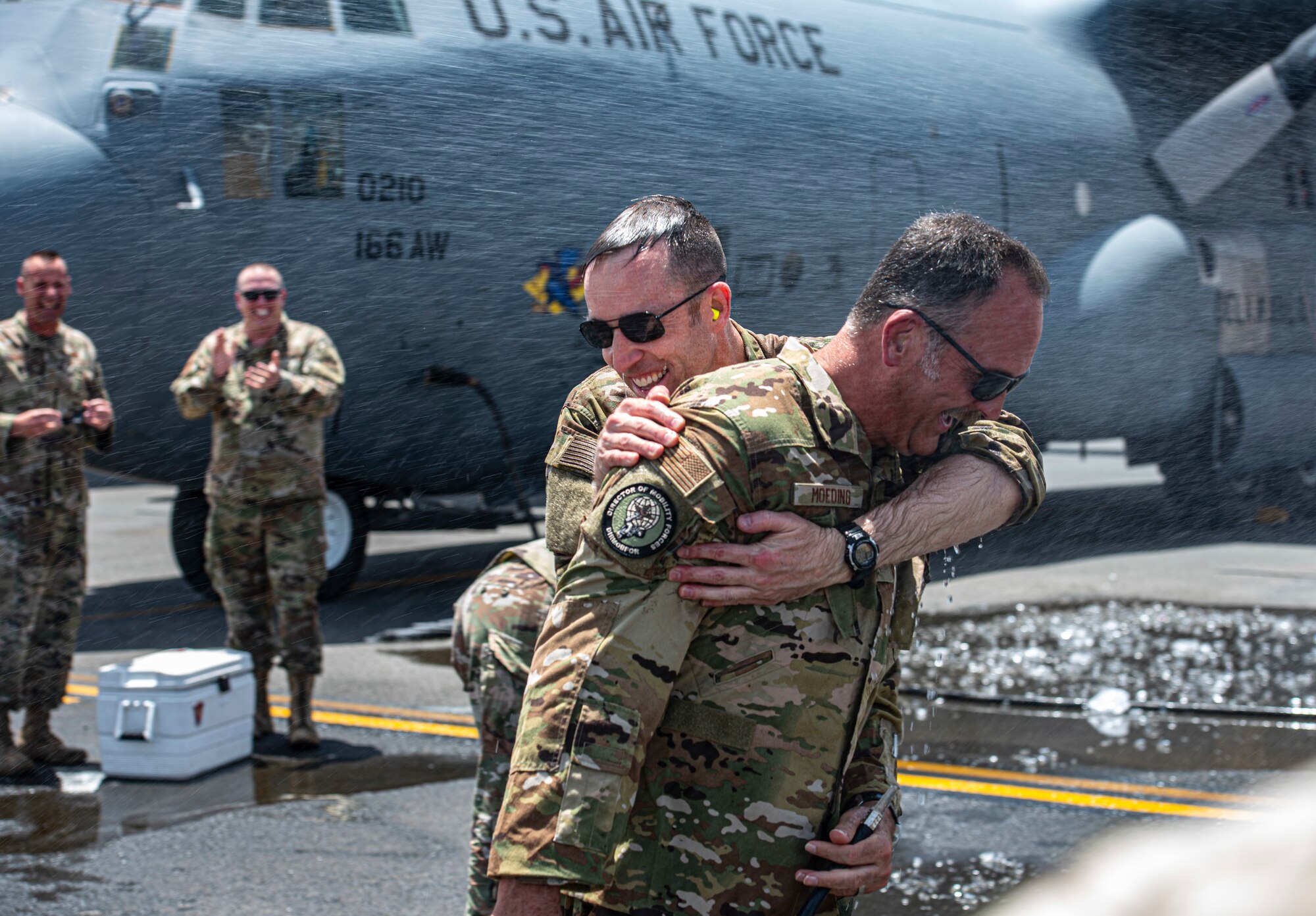 U.S. Air Force Col. Philip Shea, 407th Air Expeditionary Group commander, hugs Col. Micheal Moeding, Director of Mobility Forces, U.S. Air Forces Central, on the flight line at Ali Al Salem Air Base, Kuwait, July 4, 2021.