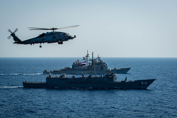 An MH-60R Sea Hawk helicopter, attached to the "Swamp Foxes" of Helicopter Maritime Strike Squadron (HSM) 74, flies above Egyptian Navy guided-missile frigate ENS Taba (FFG 916), front, and guided-missile cruiser USS Vella Gulf (CG 72) during a passing exercise with aircraft carrier USS Dwight D. Eisenhower (CVN 69), not pictured, in the Red Sea, June 29. The Eisenhower Carrier Strike Group is deployed to the U.S. 5th Fleet area of operations in support of naval operations to ensure maritime stability and security in the Central Region, connecting the Mediterranean and Pacific through the western Indian Ocean and three strategic choke points.