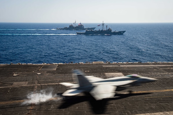 An F/A-18E Super Hornet fighter jet, attached to the "Rampagers" of Strike Fighter Squadron (VFA) 83, lands on the flight deck of aircraft carrier USS Dwight D. Eisenhower (CVN 69) as the ship conducts a passing exercise with Egyptian Navy guided-missile frigate ENS Taba (FFG 916), center, and guided-missile cruiser USS Vella Gulf (CG 72) in the Red Sea, June 29. The Eisenhower Carrier Strike Group is deployed to the U.S. 5th Fleet area of operations in support of naval operations to ensure maritime stability and security in the Central Region, connecting the Mediterranean and Pacific through the western Indian Ocean and three strategic choke points.