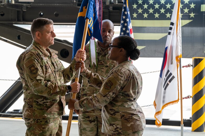 Col. Christopher Kiser, 515th Air Mobility Operations Group commander, left, presents Lt. Col. Sabrina Winter, with the 731st Air Mobility Squadron guidon during the change of command ceremony at Osan Air Base, Republic of Korea, July 1, 2021. This act marks the official beginning of Winters command of the 731st AMS. (U.S. Air Force photo by Tech. Sgt. Nicholas Alder)