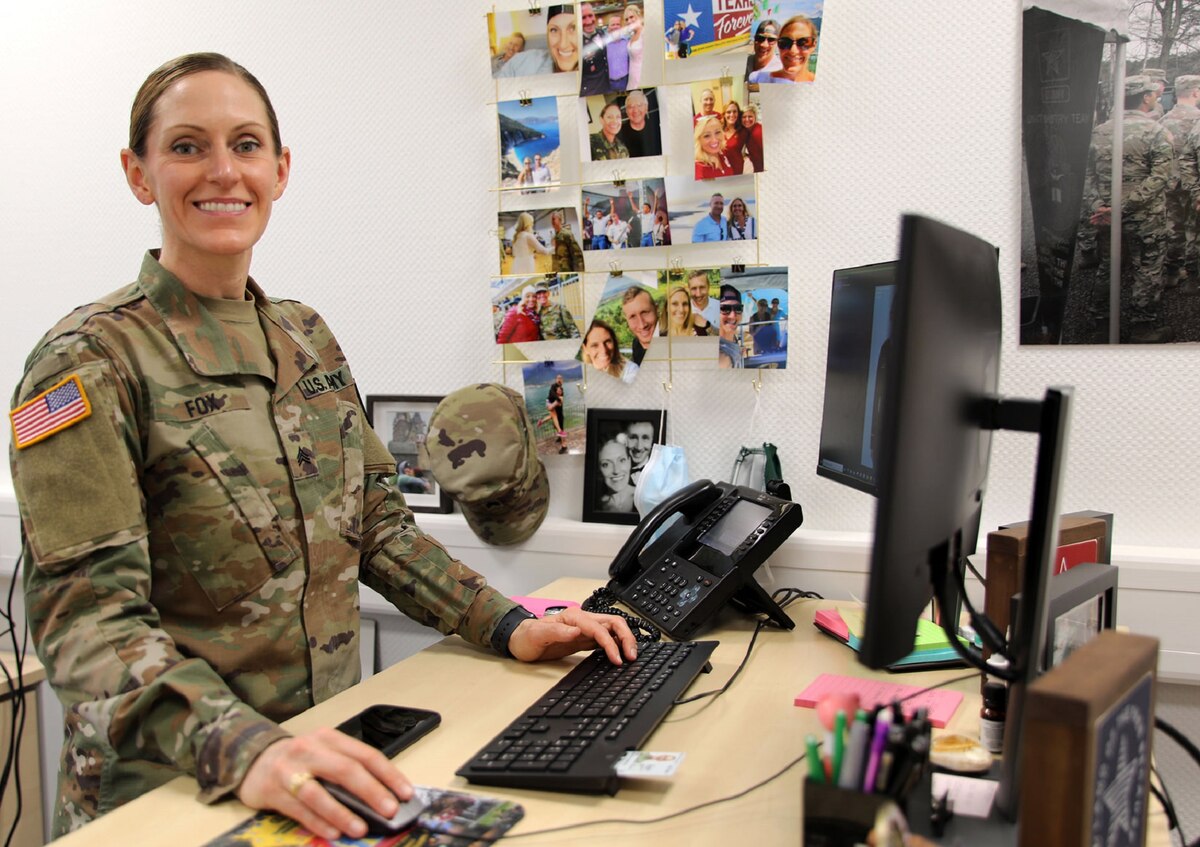 Sgt. Fox stands at her desk and smiles at the camera.