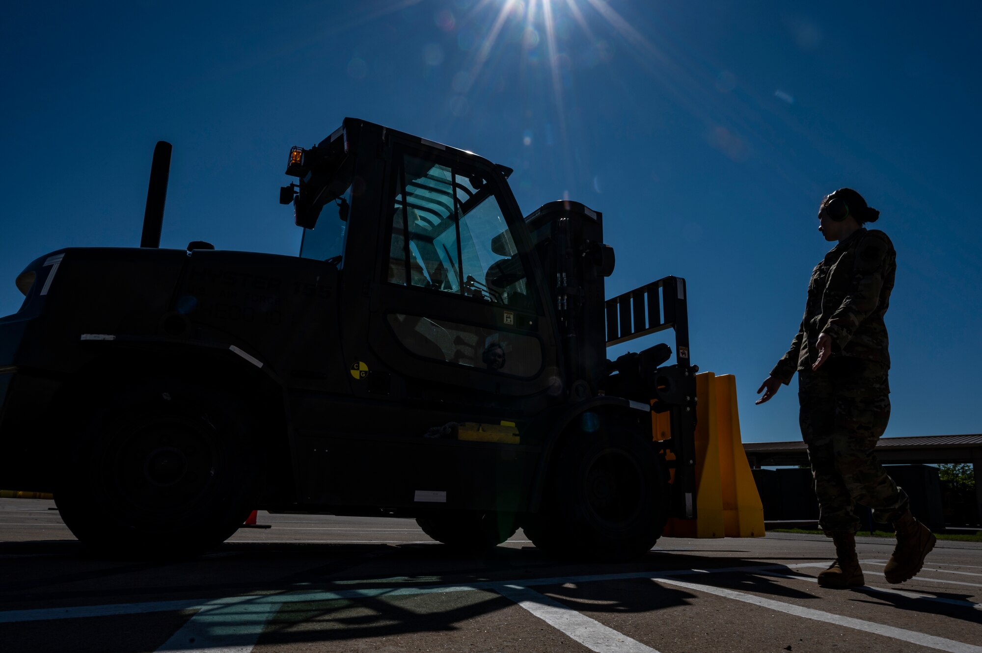 Senior Airman Brooke Hanson, 32nd Aerial Port Squadron cargo specialist, signals a fellow Airman driving a forklift to continue backing up during a training scenario at the Pittsburgh International Airport Air Reserve Station, Pennsylvania, June 16, 2021.
