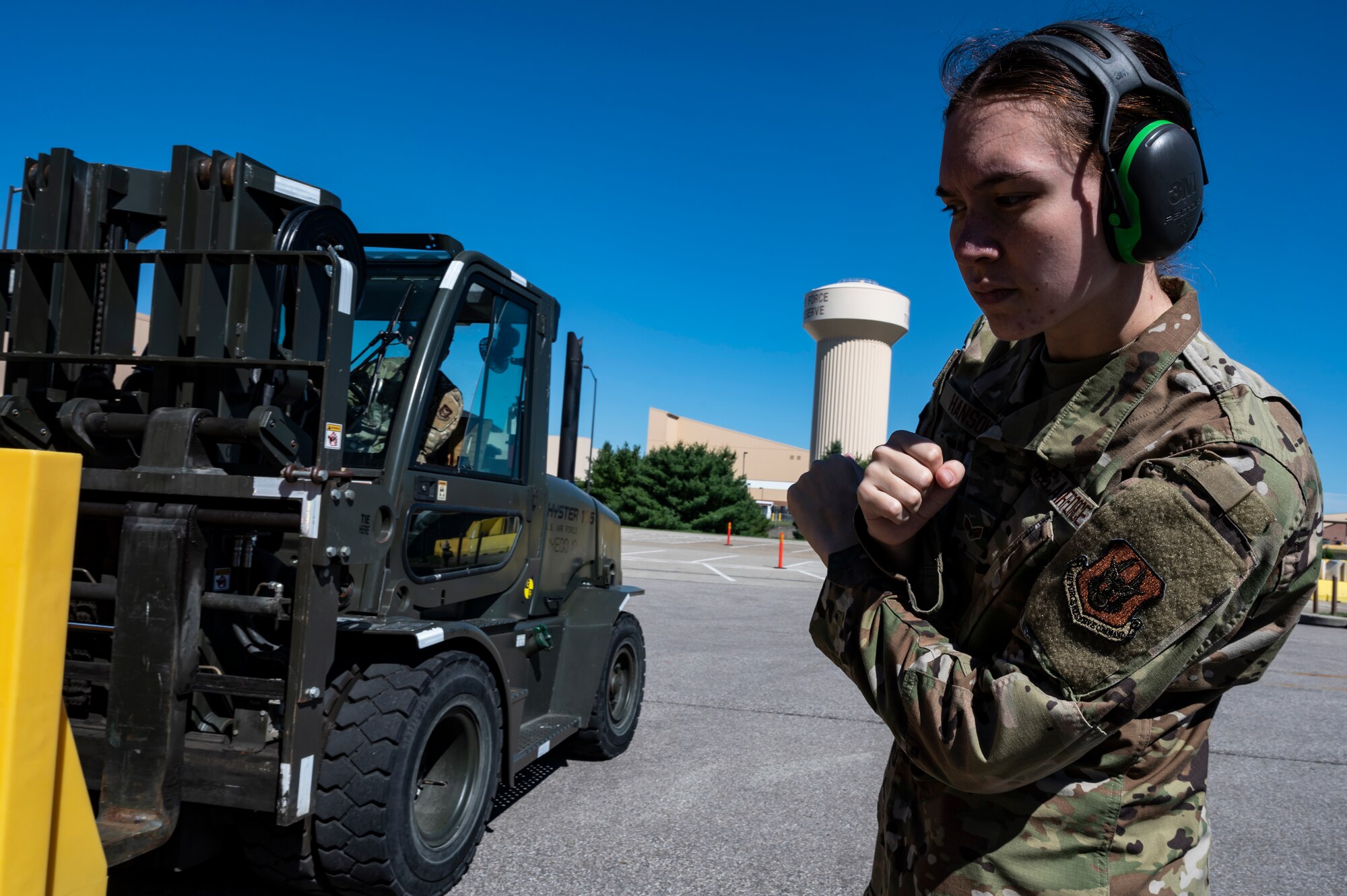 Senior Airman Brooke Hanson, 32nd Aerial Port Squadron cargo specialist, signals a fellow Airman driving a forklift to stop during a training scenario at the Pittsburgh International Airport Air Reserve Station, Pennsylvania, June 16, 2021.