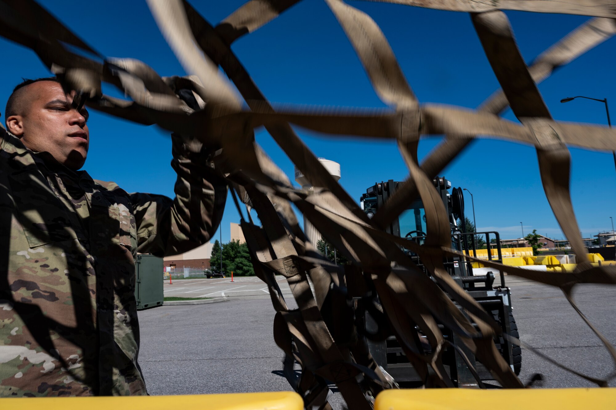 Senior Airman Zach Long, 32nd Aerial Port Squadron passenger specialist, throws a net over a cargo pallet during a training scenario at the Pittsburgh International Airport Air Reserve Station, Pennsylvania, June 16, 2021.