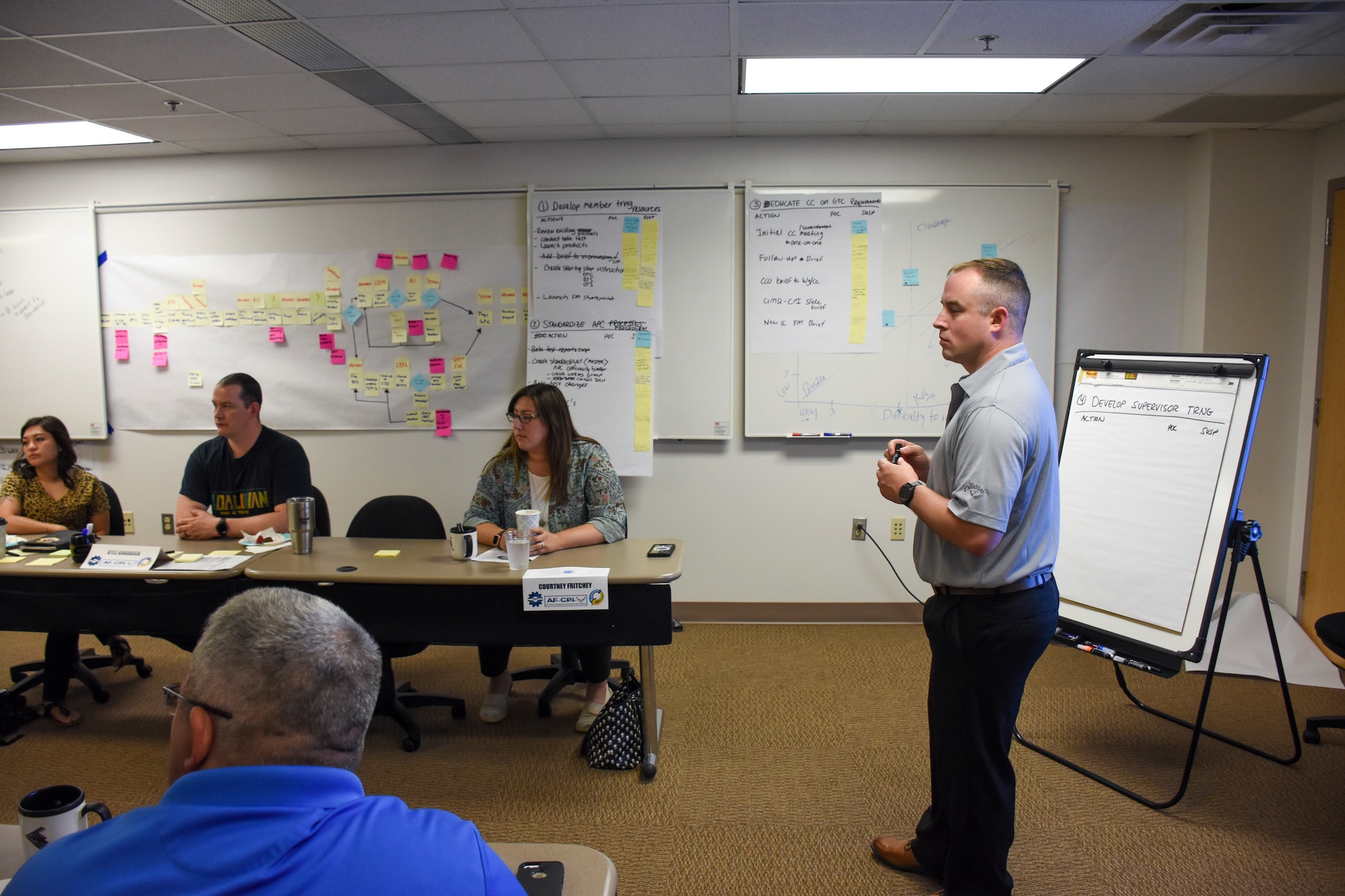 Tech. Sgt. Jeff Able stands at the front of the room while team members deliberate.