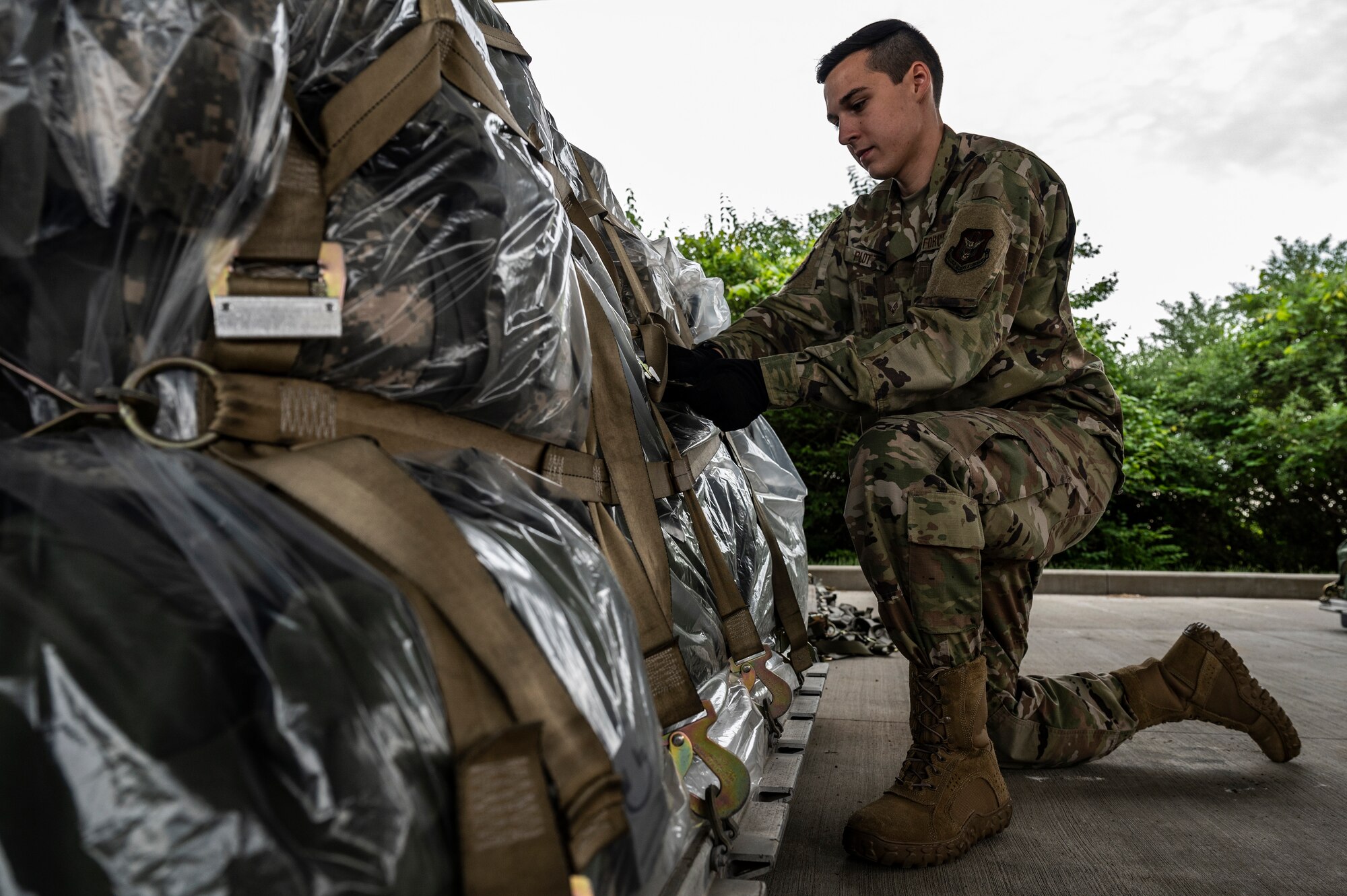 Senior Airman Logan Plotz, 32nd Aerial Port Squadron passenger service operations technician, tightens a cargo net on a pallet at the Pittsburgh International Airport Air Reserve Station, Pennsylvania, May 28, 2021.