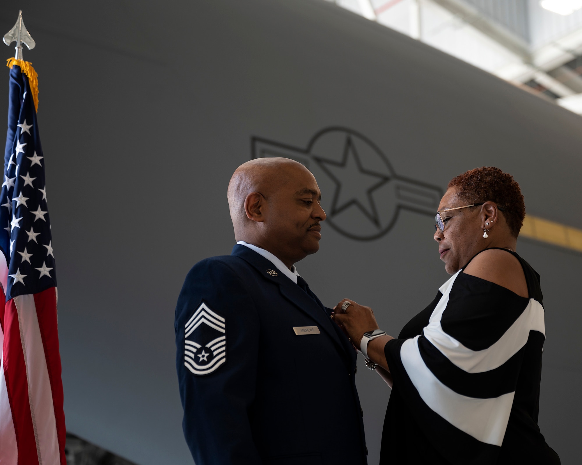 Dawn Andrews, places a retirement pin onto the uniform of her husband, Chief Master Sgt. William T. Andrews, 911th Logistics Readiness Squadron superintendent, during his retirement ceremony at the Pittsburgh International Airport Air Reserve Station, Pennsylvania, June 5, 2021.