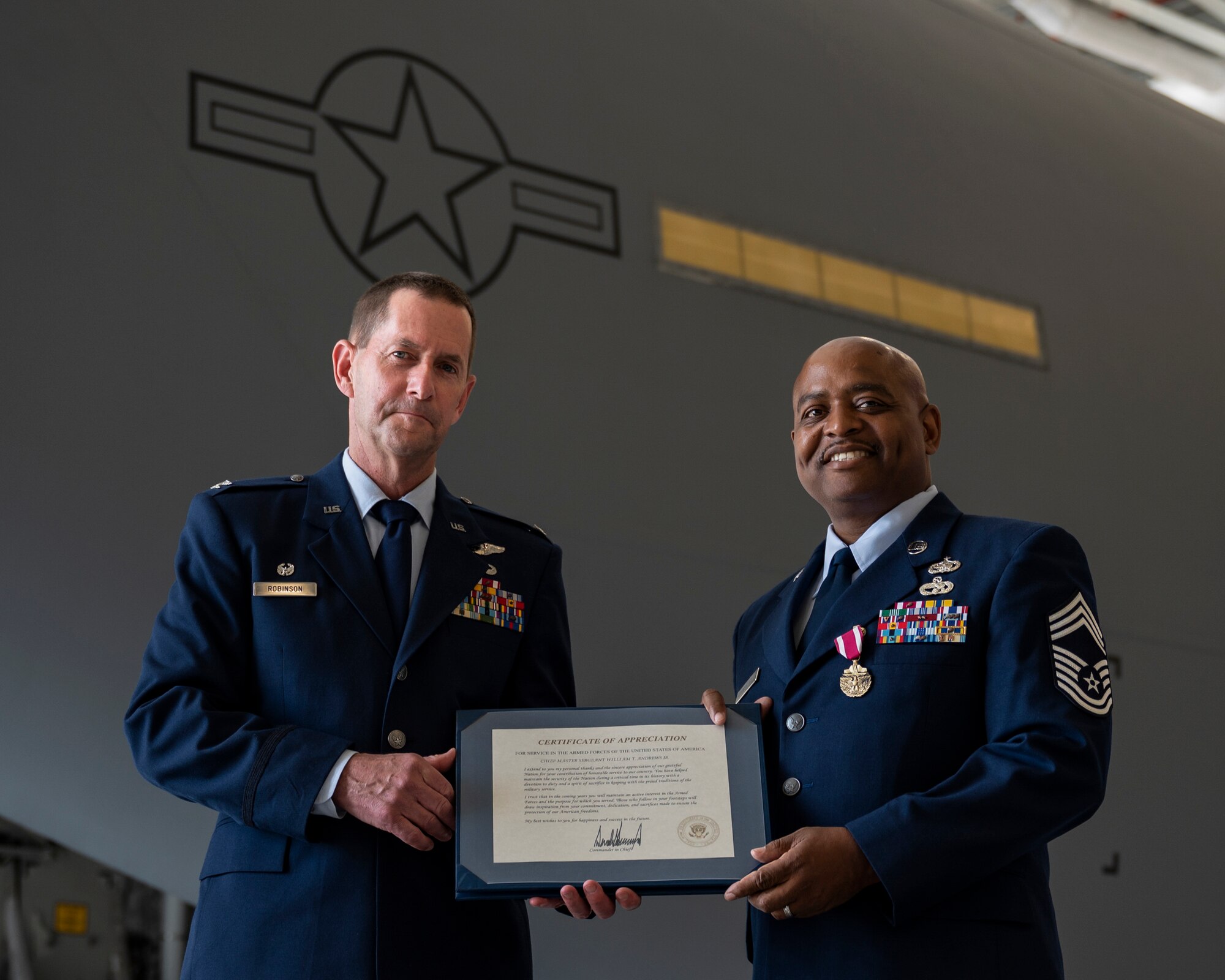 Col. John F. Robinson, 911th Airlift Wing commander, presents a certificate of appreciation for service in the armed forces to Chief Master Sgt. William T. Andrews, 911th Logistics Readiness Squadron superintendent, during a retirement ceremony at the Pittsburgh International Airport Air Reserve Station, Pennsylvania, June 5, 2021.