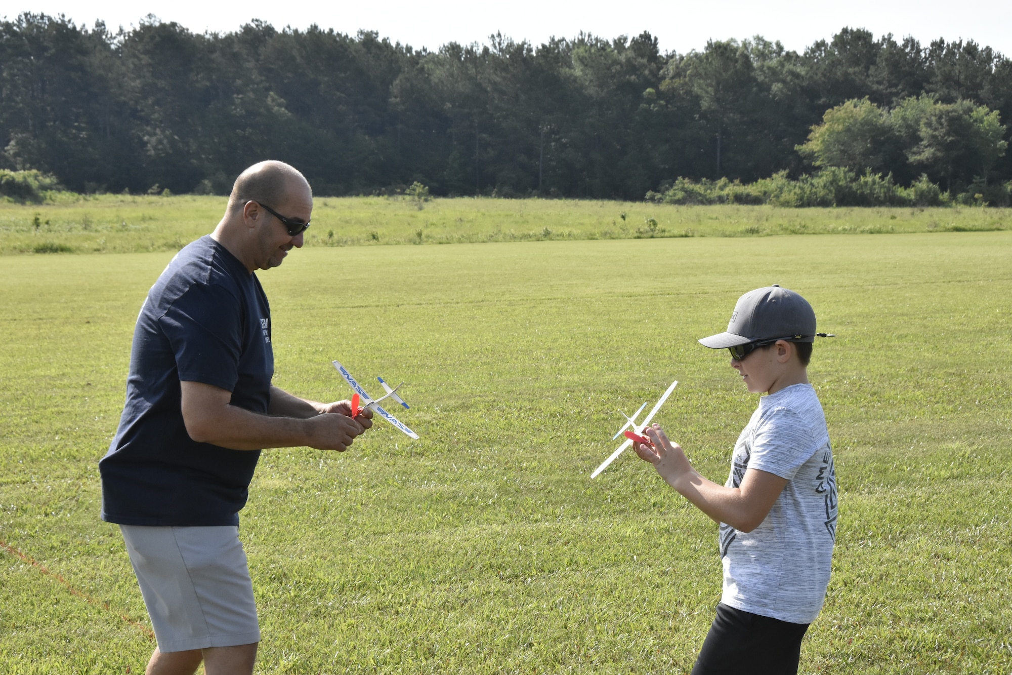 Larry Raydo, left, gives Bryce Spencer some advice on how to achieve a longer flight from his balsa wood airplane during a June 26, 2021, event hosted by the Coffee Airfoilers Model RC Club to coincide with the Arnold Engineering Development Complex 70th anniversary celebration. Youth participating in the event were tasked with assembling small balsa wood airplanes, with top prizes going to those whose planes flew the furthest from the launch line. The event was intended to promote science, technology, engineering and mathematics, or STEM, interest among students taking part. (U.S. Air Force photo by Bradley Hicks)