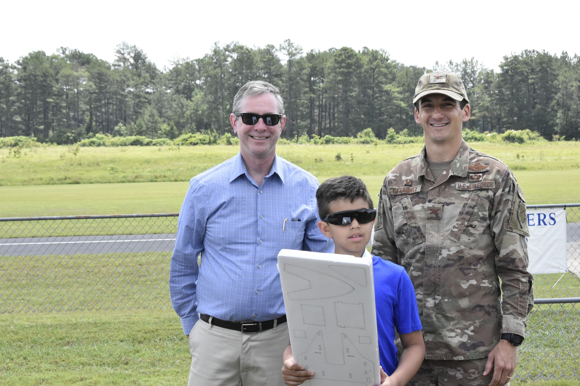 Miland Bonner, center, was a second-place winner in the Coffee Airfoilers Model RC Club June 26, 2021, airplane toss competition hosted by the club to coincide with the Arnold Engineering Development Complex 70th anniversary. Also pictured are AEDC Commander Col. Jeffrey Geraghty, right, and AEDC Vice Director Jason Coker. Youth participating in the event were tasked with assembling small balsa wood airplanes, with prizes going to those whose planes flew the furthest from the launch line. The event was intended to promote science, technology, engineering and mathematics, or STEM, interest among students taking part. (U.S. Air Force photo by Bradley Hicks)