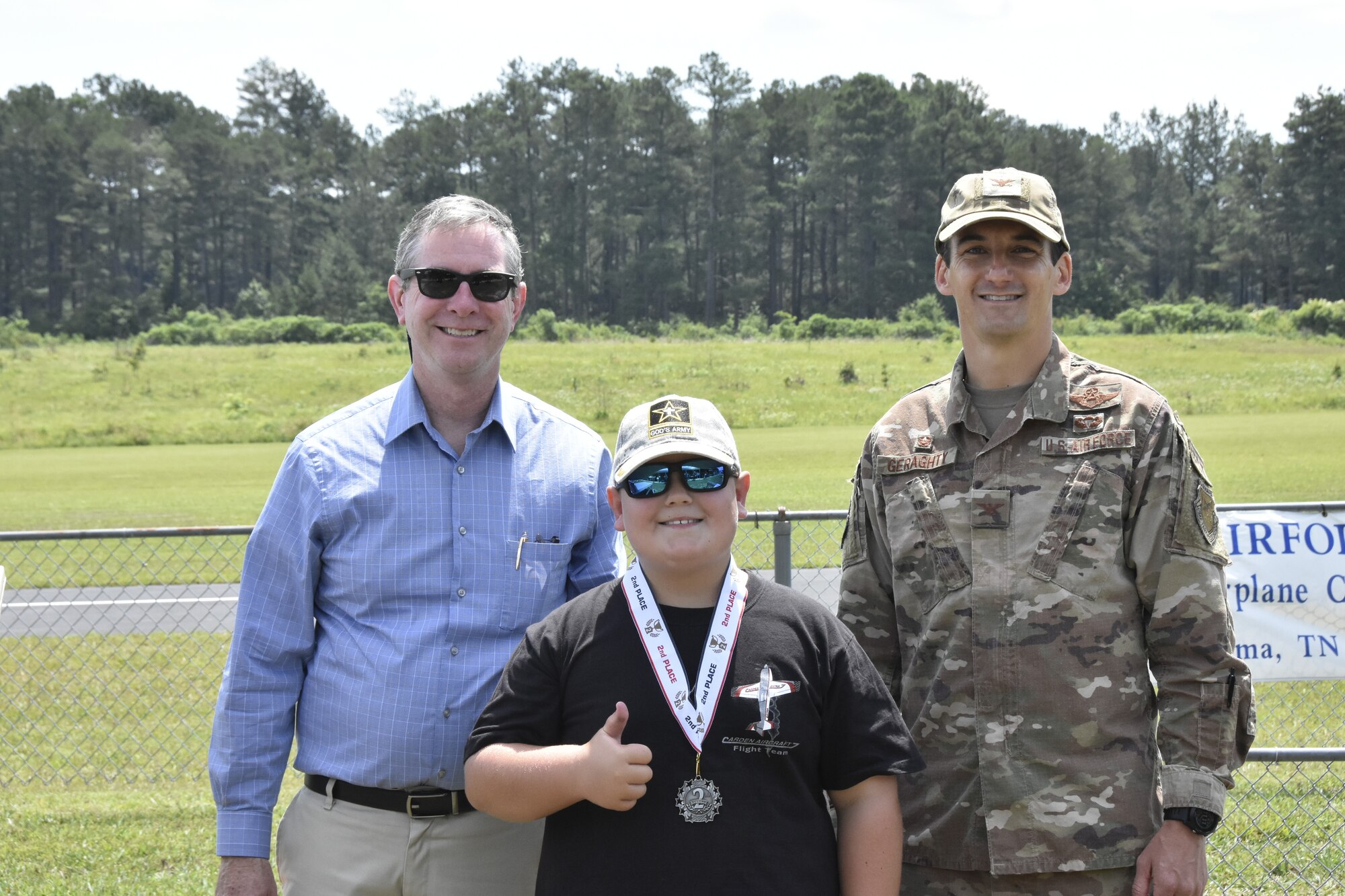 Will Jenkins, center, was a second-place winner in the Coffee Airfoilers Model RC Club June 26, 2021, airplane toss competition hosted by the club to coincide with the Arnold Engineering Development Complex 70th anniversary. Also pictured are AEDC Commander Col. Jeffrey Geraghty, right, and AEDC Vice Director Jason Coker. Youth participating in the event were tasked with assembling small balsa wood airplanes, with prizes going to those whose planes flew the furthest from the launch line. The event was intended to promote science, technology, engineering and mathematics, or STEM, interest among students taking part. (U.S. Air Force photo by Bradley Hicks)