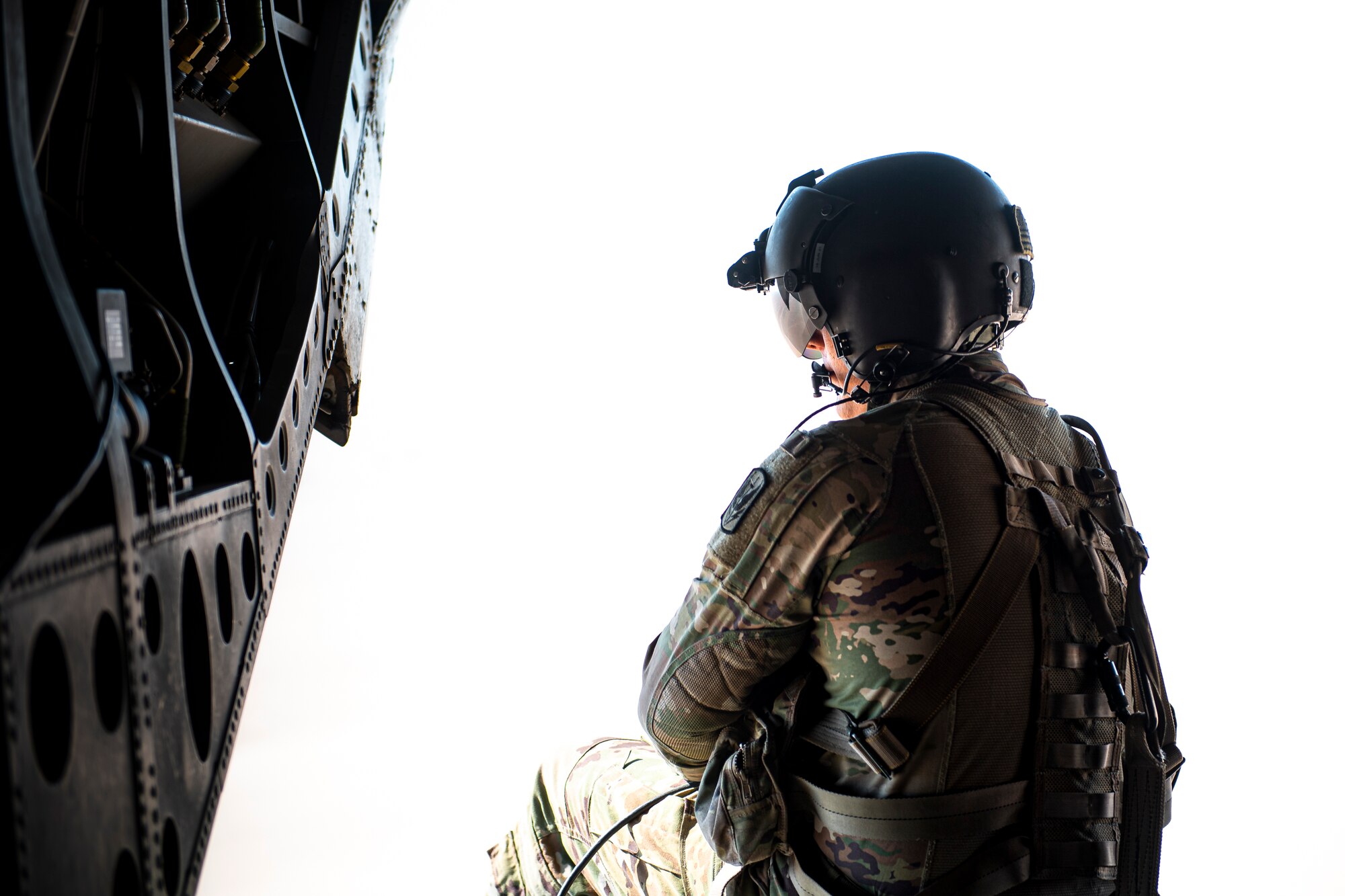 A photo of a Soldier sitting on the back of a CH-47 Chinook